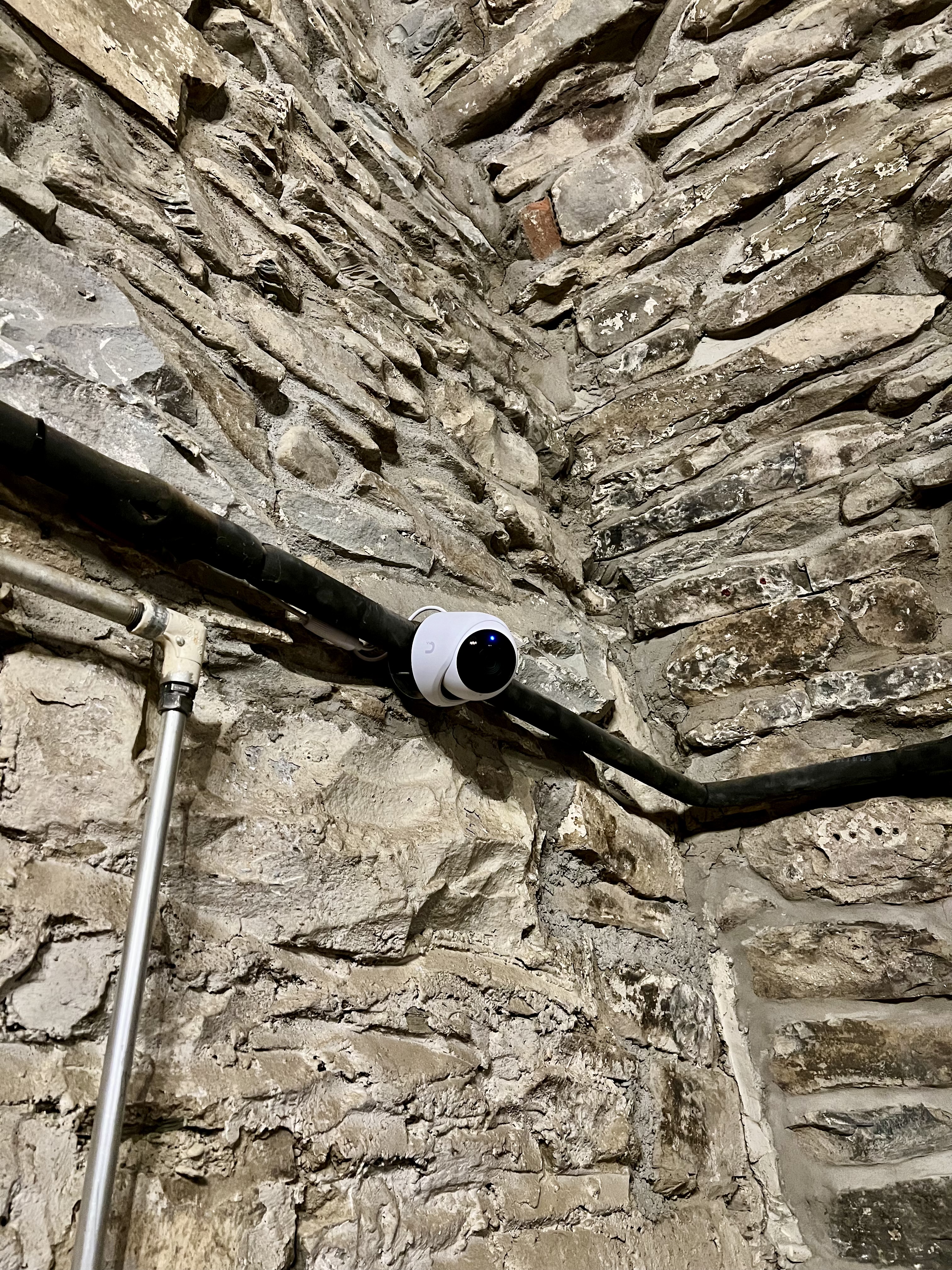 Security camera mounted on historic stone wall